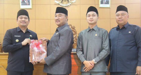 Ketua DPRD BU saat menyerahkan Perda