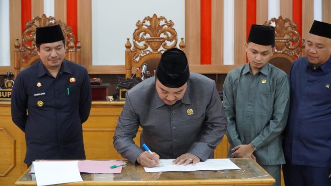 Penandatanganan dokumen pengesahan Raperda oleh Ketua DPRD BU